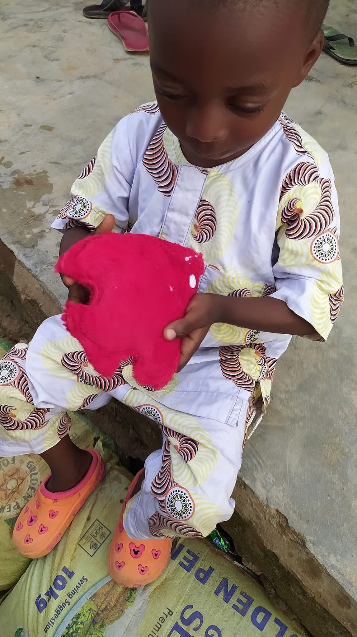 Child playing with a heart-shaped plush toy